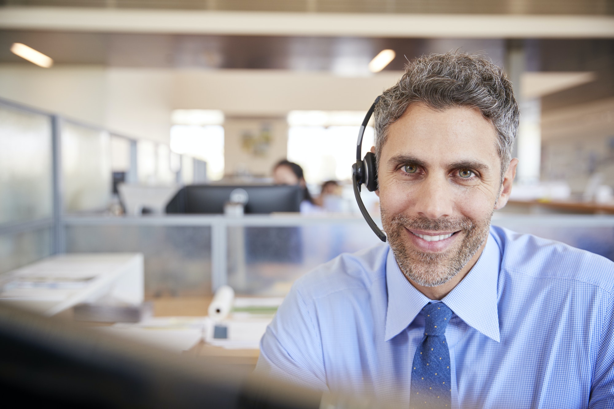 White male call centre worker smiling to camera